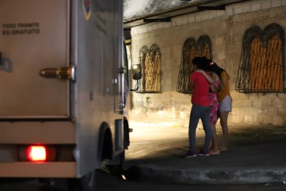 Familiares de una de las víctimas observan el levantamiento del cadáver de su allegado, en el Guasmo Central.