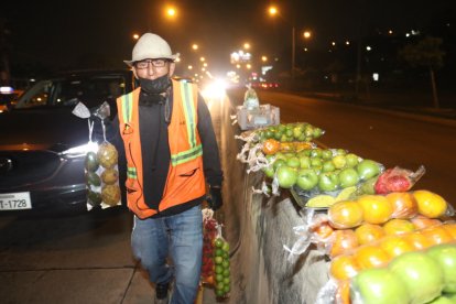 Manuel camina entre los vehículos para ofrecer las frutas.
