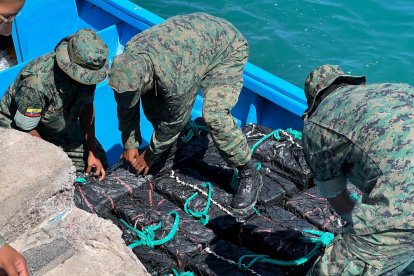 Militares bajando el cargamento de droga incautado en altamar.