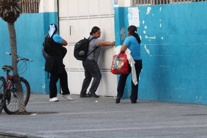 Estudiantes y padres en los exteriores de la escuela.