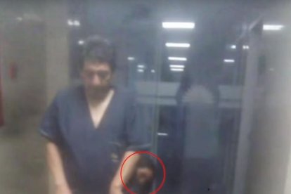 En esta imagen se muestra el rostro de la niña detrás de un trabajador.