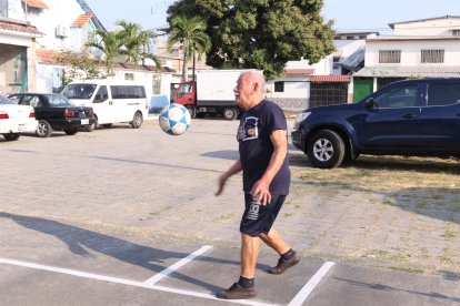 Jugador septuagenario sirviendo durante un partido de ecuavóley.