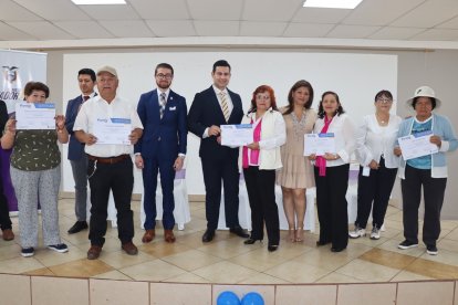 Adultos mayores muestran sus certificados tras culminar la capacitación en competencias digitales.
