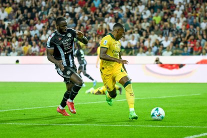 Pervis Estupinan y Keinan Davis del Udinese en acción.