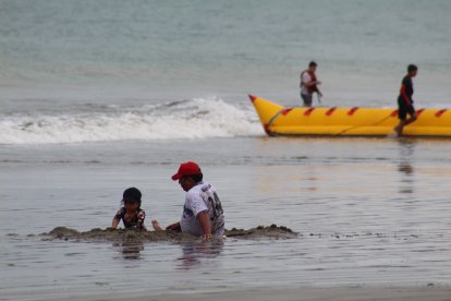 Con la brisa cálida y el sonido de las olas, unos turistas disfrutaron en este primer día de feriado por el 9 de Octubre.