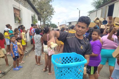 Un joven muestra los pollos que recibió y que colocó en una canasta de ropa.