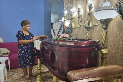 La madre de Franklin Villena observa con pesar el féretro de su hijo.