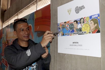 El aerógrafo Xavier Mallitasig y el boceto de la pintura con históricos del conjunto universitario.