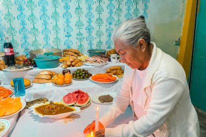Cuando la noche cae, las velas encendidas alumbran los platos en la mesa.