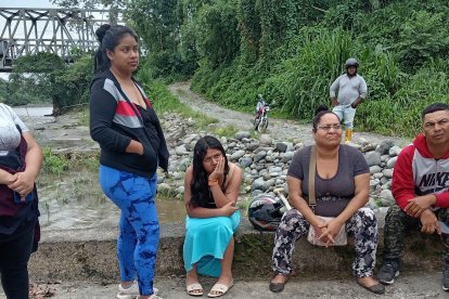 Familiares de Daniel Antonio Intriago Cedeño permanecen a orillas del río Blanco, esperando noticias de su familiar desaparecido.