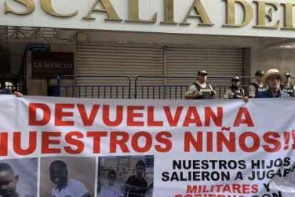 Archivo del 23 de diciembre de 2024 que muestra dos personas sosteniendo un cartel en los exteriores de la Fiscalía Provincial del Guayas.