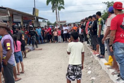 Moradores del sector rodean la escena del crimen a la espera de que la policía realice las pericias.
