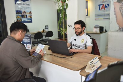 Los asesores legales migratorios como Cristian Silva (d) de visas guían a los aficionados para aplicar el beneficio del FIFA Pass