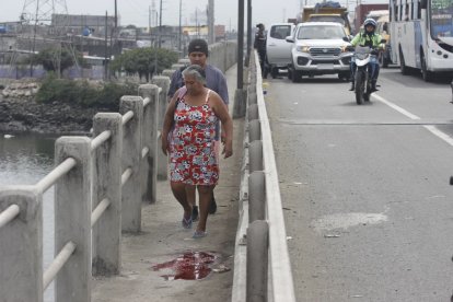 Transeúntes debían evitar el charco de sangre para cruzar el puente.