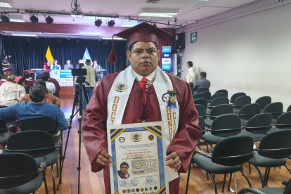 El abogado Paúl Moreno mientras sostiene su nuevo título.