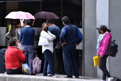 Las personas esperan afuera de un hospital del sur de Quito.
