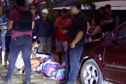 Familiares lloran desconsolados sobre uno de los cuerpos sin vida. La violencia les golpeó en la previa navideña