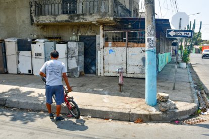 El esposo de la fallecida observa con tristeza el lugar donde cayó la madre de sus hijos. Aún permanecían visibles las manchas de sangre.