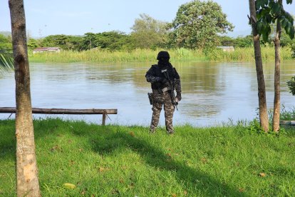 Un agente fuertemente armado vigila las riberas del río Esmeraldas, zona estratégica en la disputa entre grupos delictivos que buscan controlar el territorio.