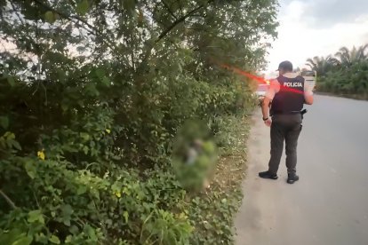 Agentes policiales custodian el área del hallazgo en la vía La Independencia, mientras se esperan las diligencias de criminalística.
