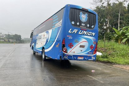 La parte posterior del bus de la cooperativa La Unión muestra daños tras el impacto con una motocicleta en el sector El Consuelo, vía E20.