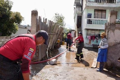 María Alulema señala la altura a la que llegó el agua dentro de su vivienda.