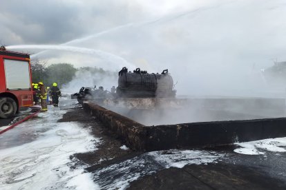 Bomberos en Esmeraldas combaten las llamas en un contenedor industrial, utilizando agua y espuma para sofocar el fuego y asegurar la zona afectada.