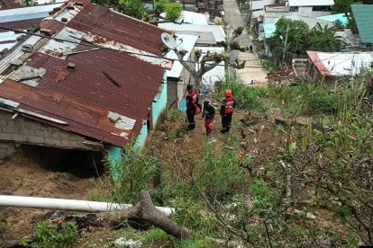 Bomberos inspeccionan una vivienda afectada por deslizamiento en el barrio 20 de Noviembre, donde las lluvias intensas han puesto en riesgo a varias familias