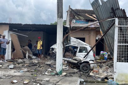 Escombros de la vivienda impactada por el tráiler en La Victoria, mientras vecinos observan los daños y la magnitud del accidente.
