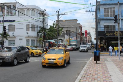 Un taxi circula por una concurrida avenida de Esmeraldas, donde la desaparición temporal de un conductor generó alarma ciudadana y mantiene abierta la búsqueda de su vehículo.