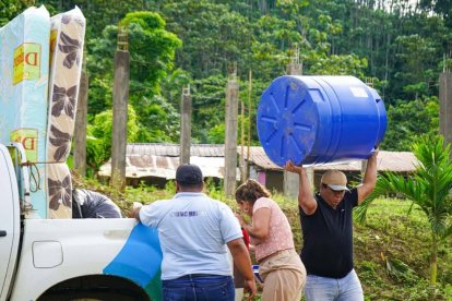 Autoridades y voluntarios descargan colchones, alimentos y un tanque de agua en el recinto Palma Real, como parte de la ayuda humanitaria para la familia afectada por el incendio en San Gregorio.