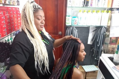 María Arroyo mientras peina a una de sus clientas.