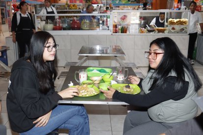 Varias universitarias acuden al puesto de la casera para comer un plato de corvina.