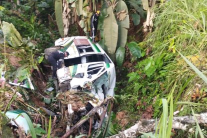 Equipo de rescate utiliza cuerdas para extraer a dos pasajeros atrapados entre los hierros retorcidos del vehículo.