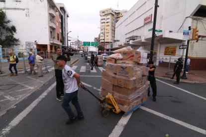 Comerciantes rescatan mercadería de la zona cero del incendio.