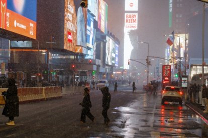 Un vendedor ambulante trabaja en su carrito de perritos calientes en Times Square durante la tormenta de nieve que azota Nueva York, Nueva York. EFE/Olga Fedorova