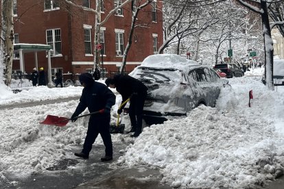Personas recogen nieve cerca del Washington Square Park este lunes, en Nueva York (Estados Unidos)