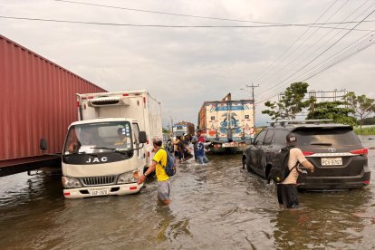 Algunas personas buscan ganar unas monedas ayudando en la inundación.
