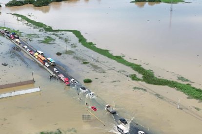 Las personas cruzan caminando y otras en canoa.