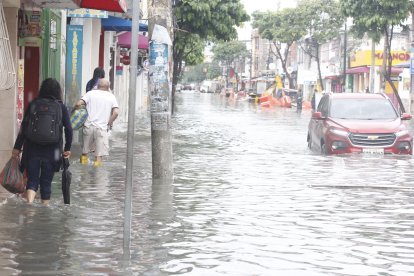 Moradores de zonas inundadas usaron botas impermeables y bolsas plásticas para movilizarse durante la jornada lluviosa.