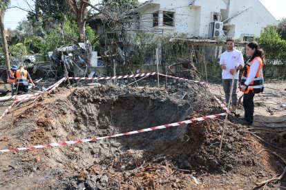 Los residentes inspeccionan los daños después de que un cohete lanzado por Hezbolá desde Líbano impactara en una casa en Moshav Haniel.