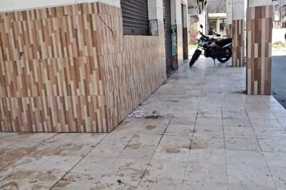 En la acera exterior de la vivienda de la víctima, entre las columnas, se observan manchas de sangre que señalan el lugar preciso del ataque.