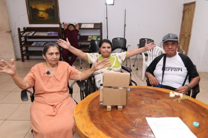 Participantes del asilo siguen las indicaciones del robot y realizan ejercicios de estiramiento. Laura Rendón, vestida de rosado, está en el grupo.