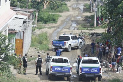 Camionetas de la Policía Nacional permanecen en el sector Sergio Toral, en el noroeste de Guayaquil, mientras se realizan las diligencias tras el crimen del adolescente.