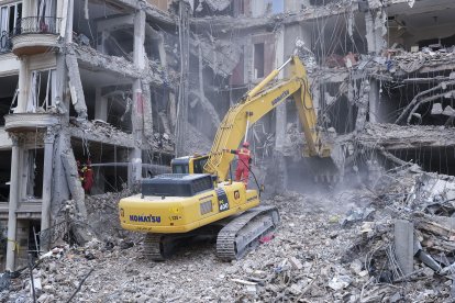 Unos trabajadoras desescombran con una excavadora un edificio que fue atacado por Estados Unidos e Israel en el barrio de Andarzgu, en el noreste de Teherán.