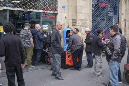 Un grupo de personas hace fila en una tienda de generadores eléctricos en la calle Saadi, en Teherán, ante el temor de una crisis energética.