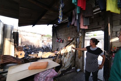 Vecina afectada observa los daños tras el incendio en su vivienda.