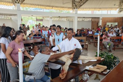 Un devoto en silla de ruedas besa la imagen de Cristo durante la Adoración de la Cruz en Esmeraldas, en un acto de fe y gratitud.
