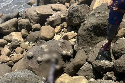 Dos personas permanecen entre las rocas del sector costero de Atacames, en medio del operativo tras el hecho registrado en el Peñón del Suicida.