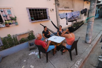 La familia de Miguel descansaba también en la acera mientras jugaba.